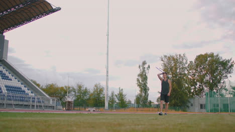 javelin-throw-back-athlete-thrower-in-track-and-field-event.-Undefined-athlete-javelin-throwing-during-Athletics-Championships.-Sportsman-practising-javelin-throw-against-blue-sky-with-clouds